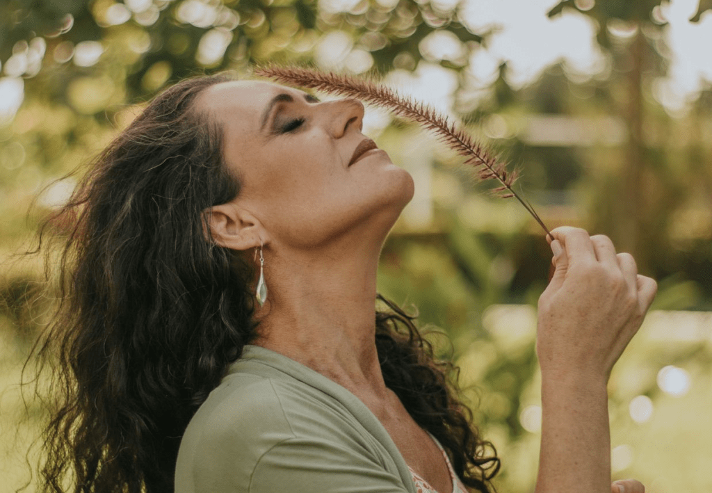 Mulher de cabeça levemente para trás com um ramo