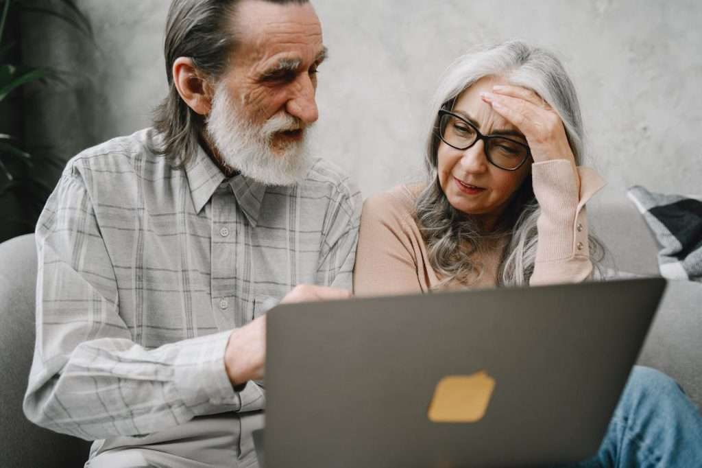 casal de idosos olhando para computador