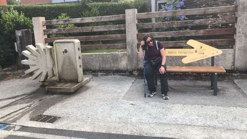 mulher sentada em um banco com seta escrita peregrino