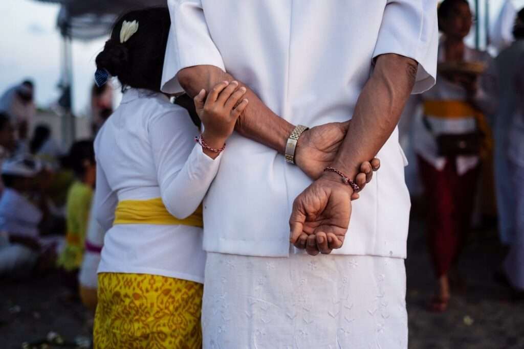 idosa de branco e criança negra de branco e amarelo de costas