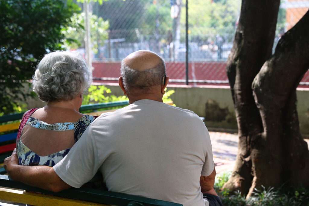 Casal de idosos de costas, ele semicareca e ela cabelos curtos e grisalhos