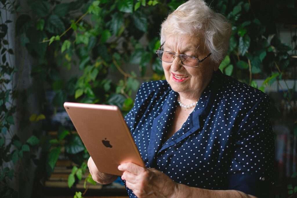 idosa de cabelo curto e branco, segura um tablet