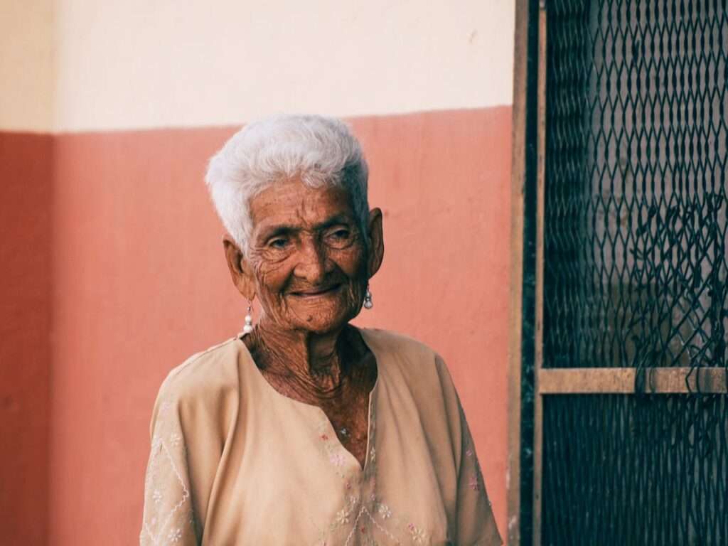 idosa, cabelo curto e branco, sorri pra foto