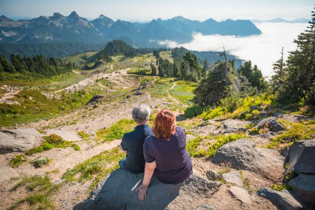 casal de idosos de costas olham as montanhas