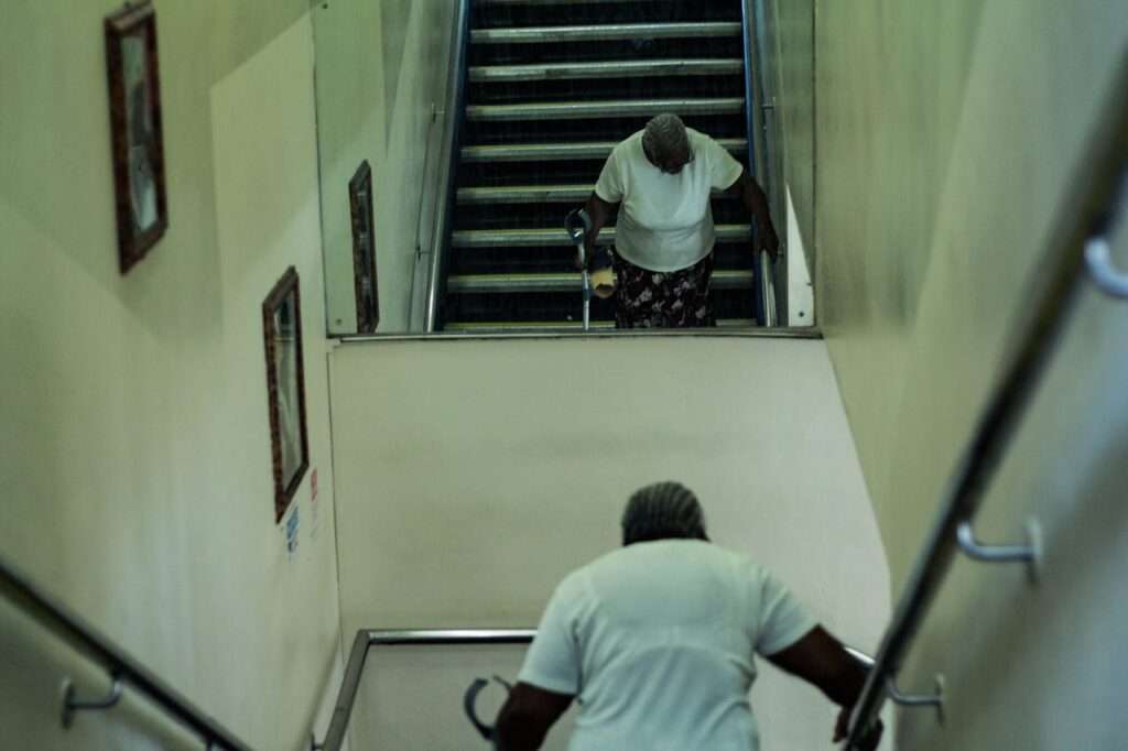 idosa negra desce escadarias de estacao de metro