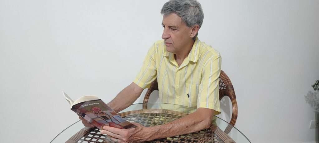 Idoso de camisa amarela le um livro Vida Moinho