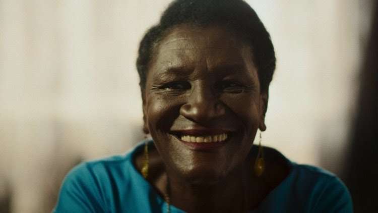 idosa, negra, sorri para a camera
