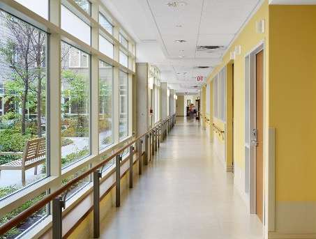 andar com parede pintada de amarela e vidraça em frente, dando para área verde.