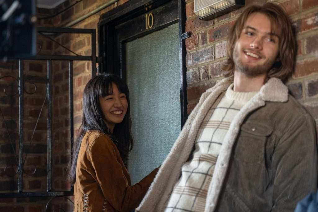 casal de jovens, ela oriental e ele europeu, em um ambiente com parede de tijolo